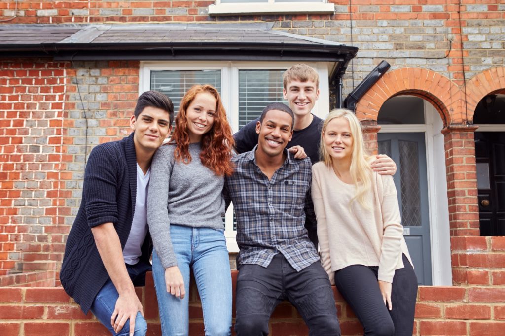 Portrait Of Group Of Smiling College Students Outside Rented Shared House